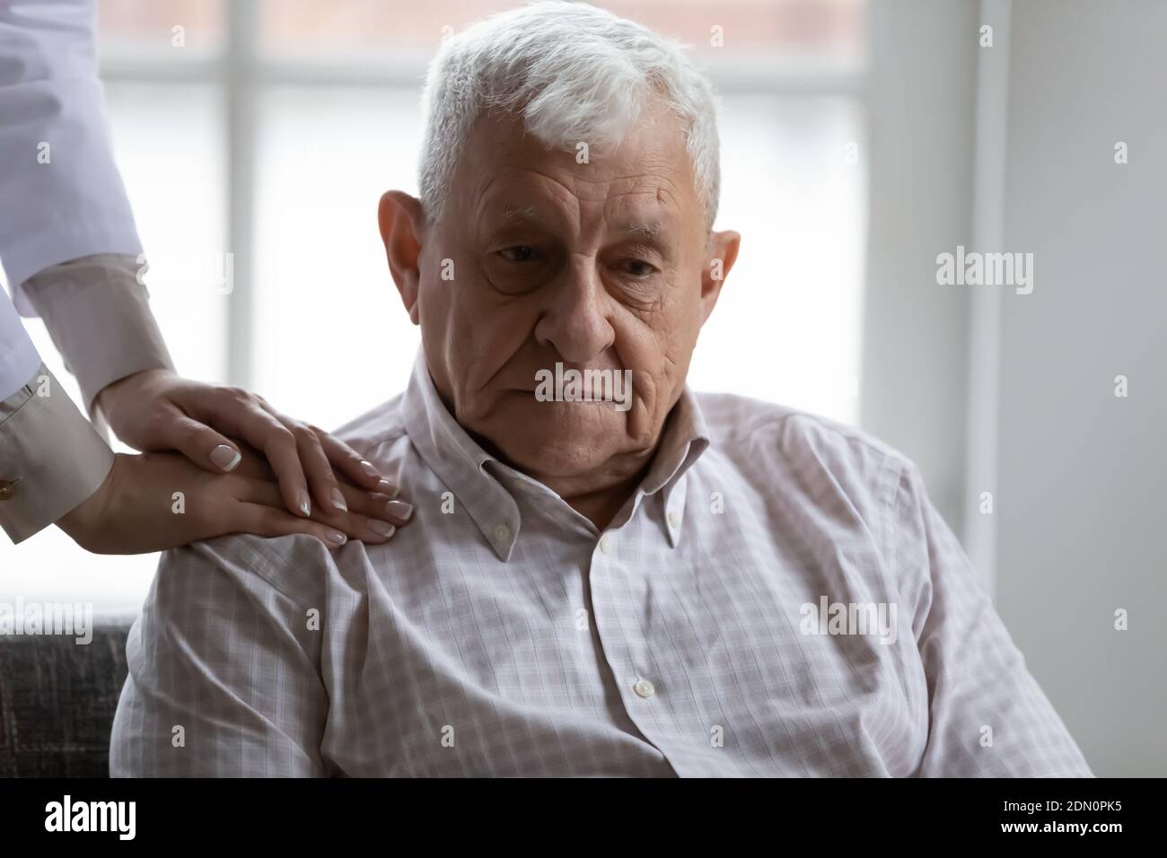 Il medico mani sulla spalla di pazienti anziani che soffrono di demenza Foto Stock