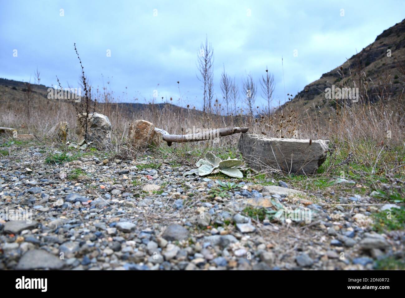 Pietre con un palo di legno che delimita un terreno in una zona di montagna. Foto Stock