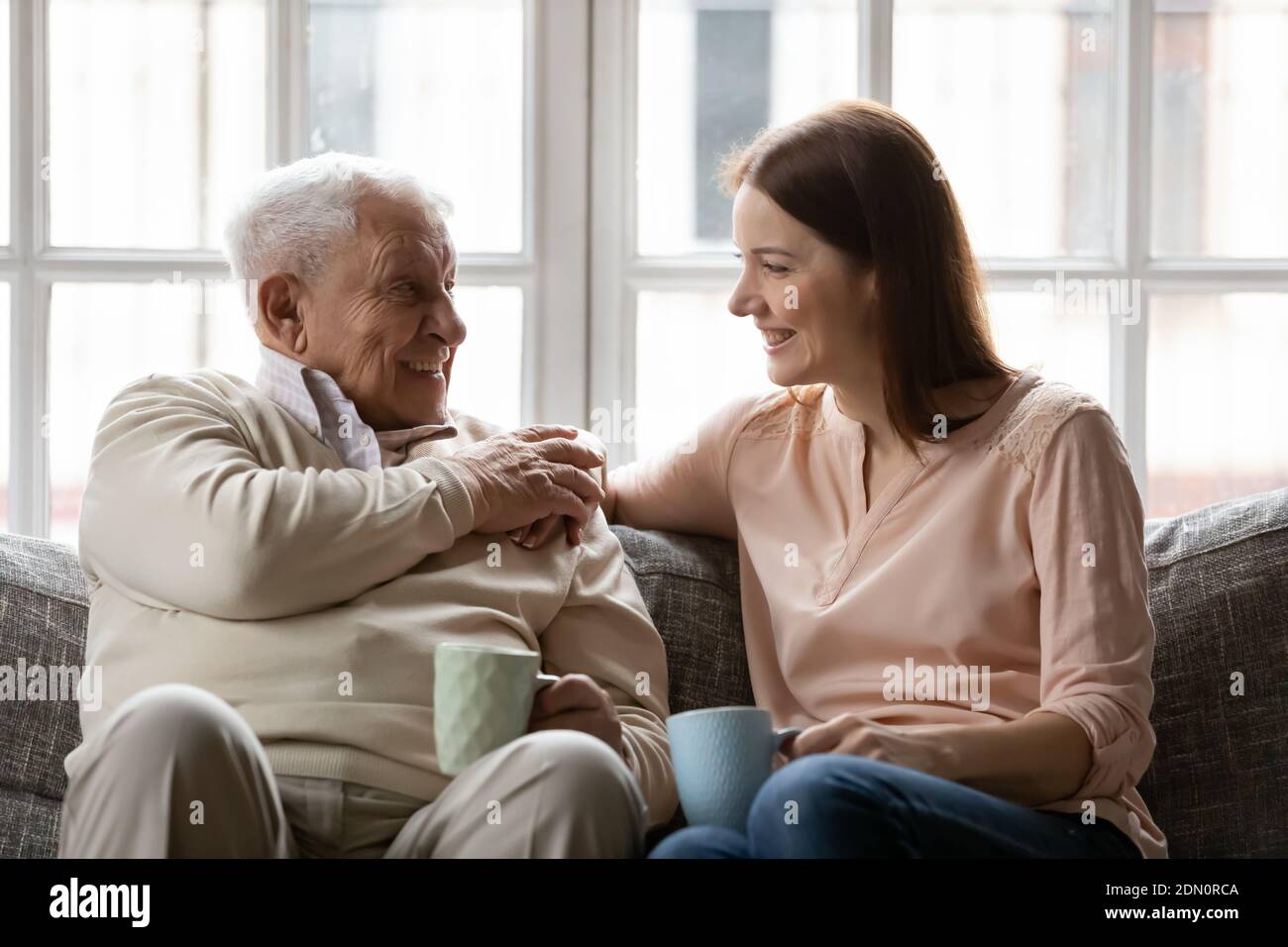Il padre anziano gode di conversazione con la figlia per una tazza di tè Foto Stock