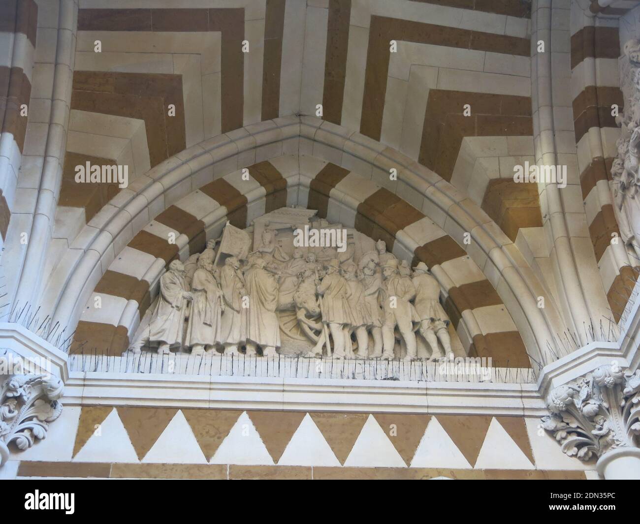 Una delle scene scolpite della storia di Northampton nella scultura ornata in un arco sopra la finestra del Guildhall, Piazza San Giles, Northampton. Foto Stock