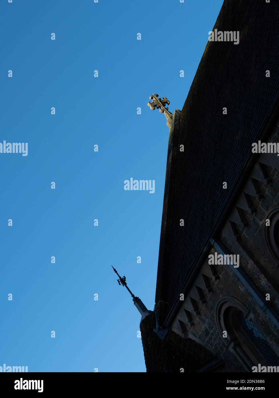 Croce di pietra e conduttore di fulmine isolato contro il cielo blu su Church of Holy Trinity, Dilton Marsh, Wiltshire, Inghilterra, UK. Foto Stock