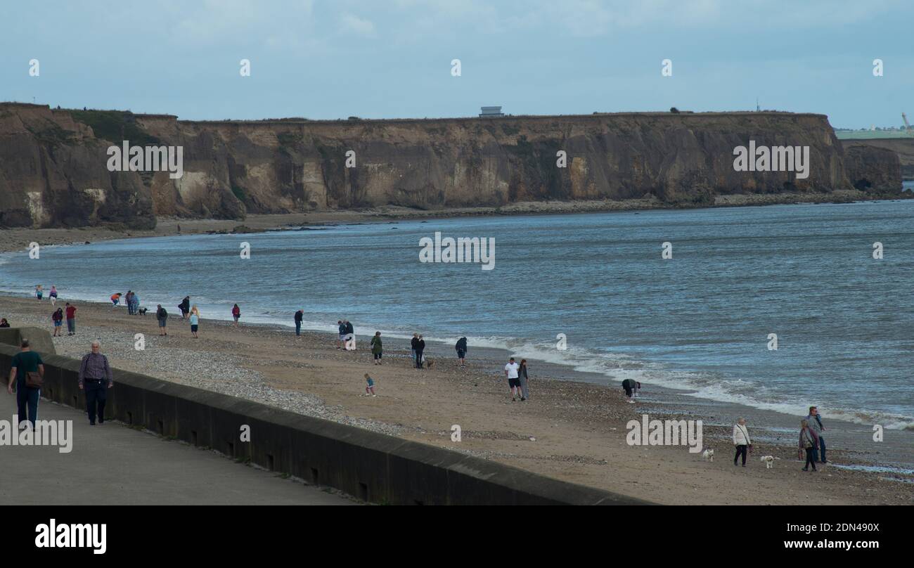 Spiaggia di Seaham e passeggiata nella contea di Durham con persone a piedi lungo la spiaggia, mantenendo le distanze sociali durante il 2020 pandemia Foto Stock