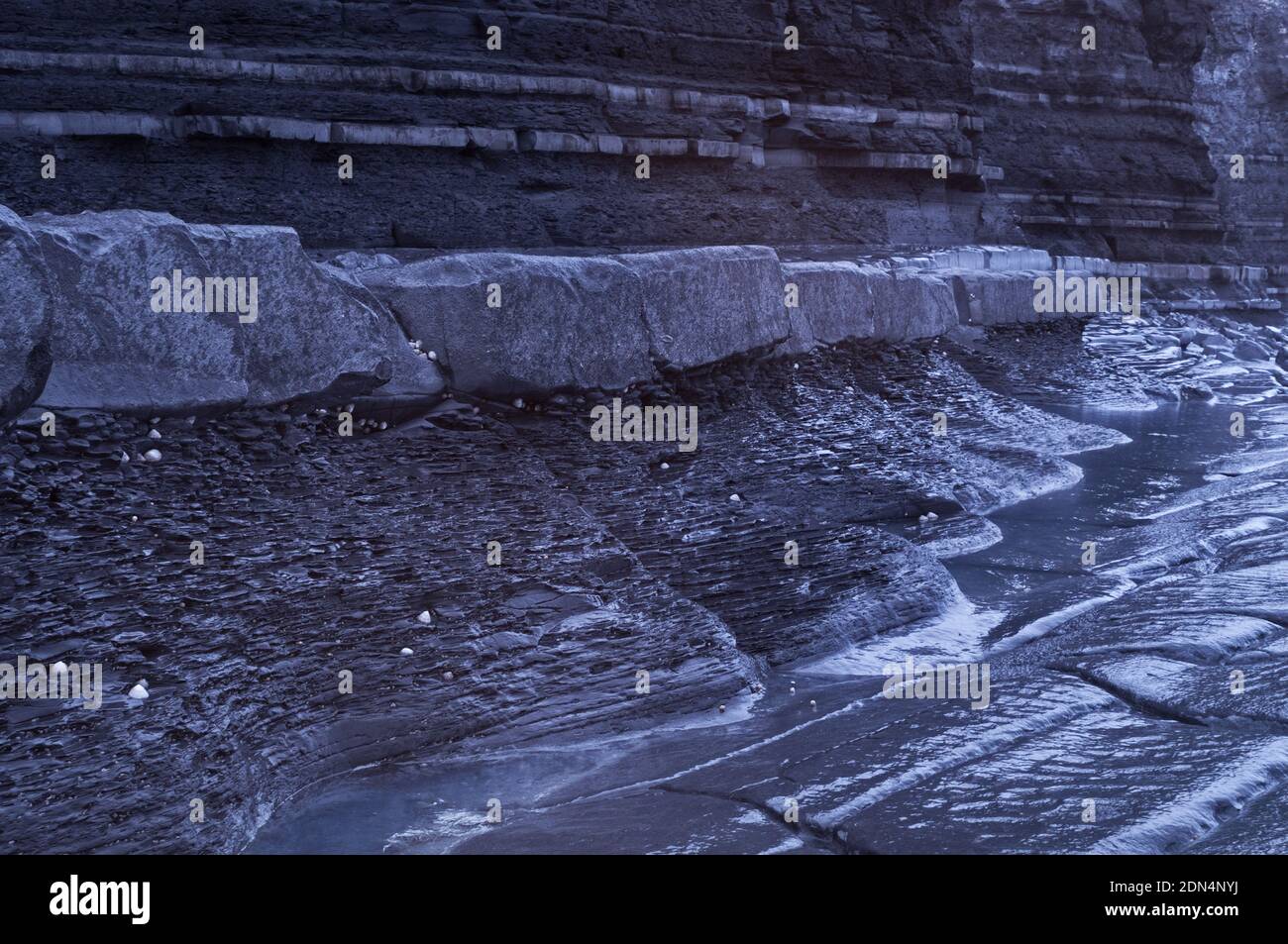 Foto infrarossa scattata a bassa marea del litorale roccioso del Jurassic sotto le scogliere a Kilve Beach, Somerset, Inghilterra, Regno Unito Foto Stock