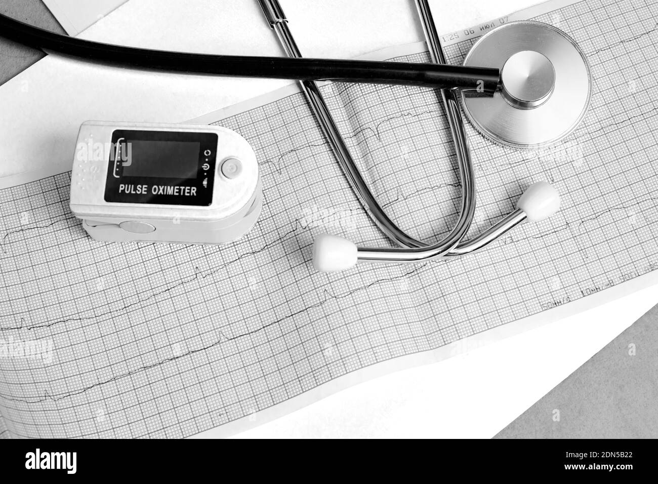 Un pulsossimetro e uno stetoscopio su sfondo blu, retro e bianco Foto Stock
