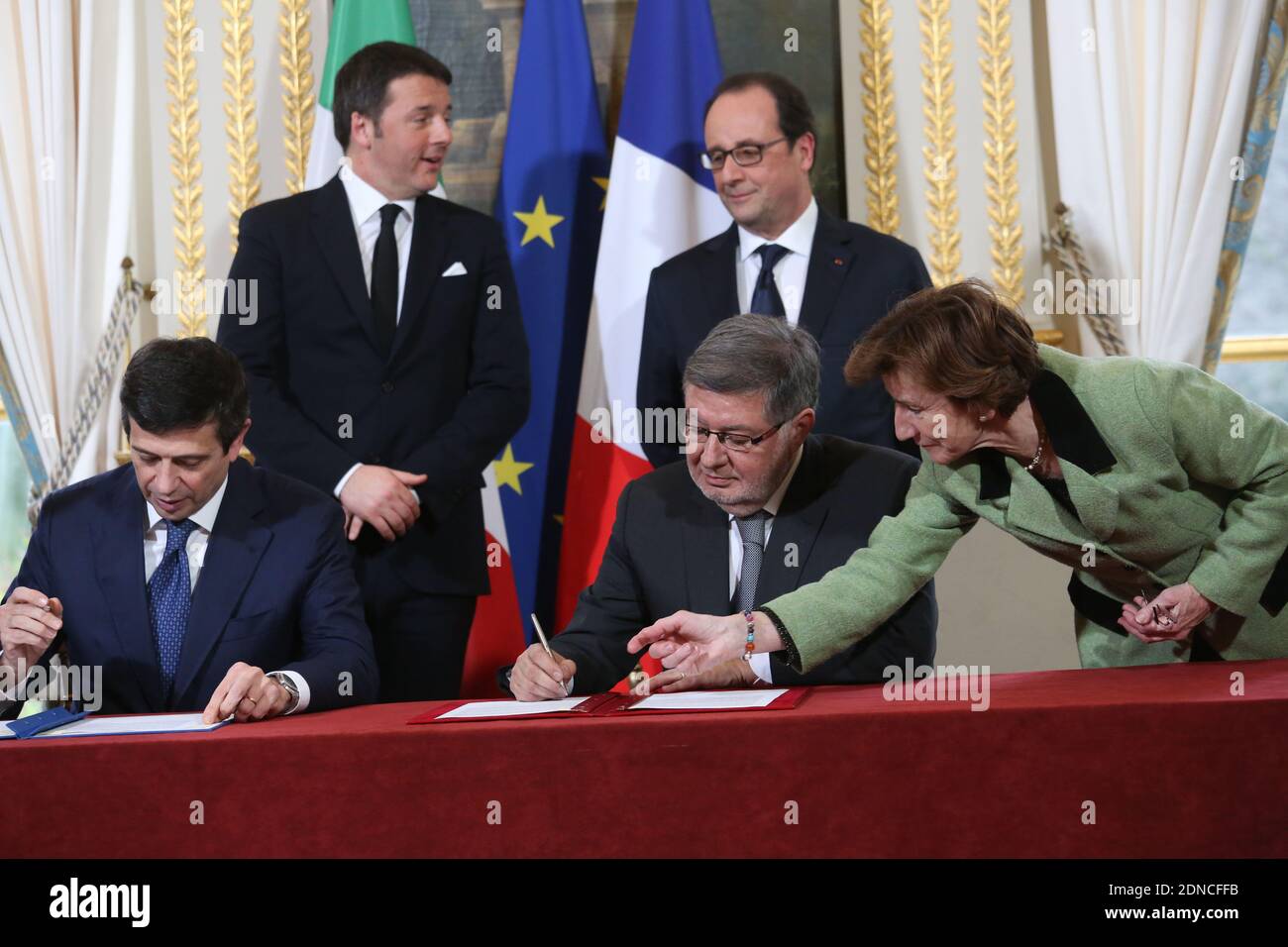 Ministro italiano delle infrastrutture e dei trasporti Maurizio Lupi (fronte L) e Segretario di Stato francese per i trasporti, la Marina e la pesca Alain Vidalies (fronte R) Firma di un accordo per la costruzione della ferrovia ad alta velocità Torino-Lione, mentre il presidente francese Francois Hollande e il primo ministro italiano Matteo Renzi guardano durante una cerimonia di firma che chiude il 24 febbraio 2015 il vertice franco-italiano svoltosi presso l'Elysee Palace di Parigi. Foto piscina di Hamilton/ABACAPRESS.COM Foto Stock