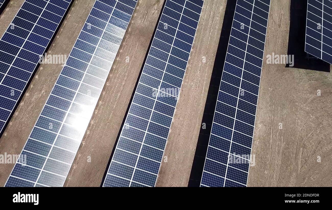 Pannelli solari nel deserto. Vista dall'alto dei moduli fotovoltaici in un impianto di energia solare sullo sfondo di una fattoria Foto Stock