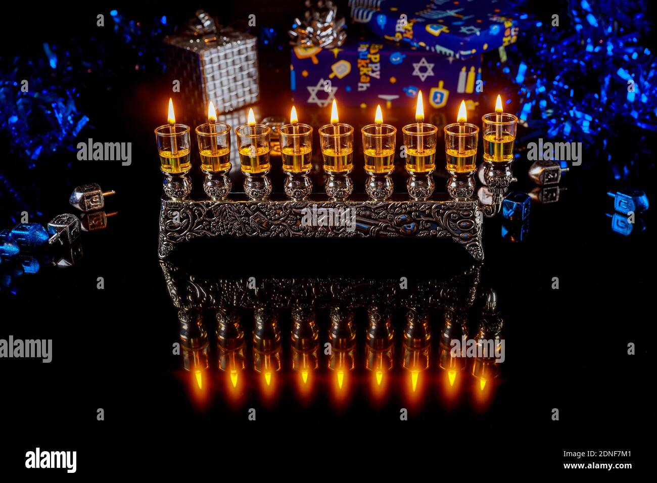 Menorah with burning candles with reflection for Hanukkah jewish holiday. Foto Stock