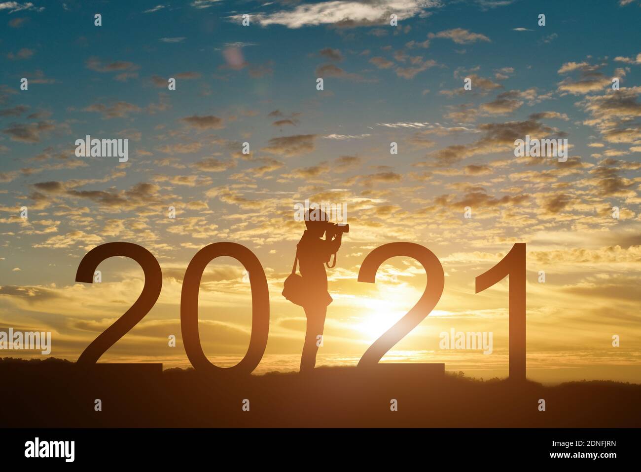 Silhouette di fotografo che scatta foto in 2021 anni all'alba o sullo sfondo del tramonto, con spazio per la copia. Idea per felice anno nuovo 2021. Foto Stock