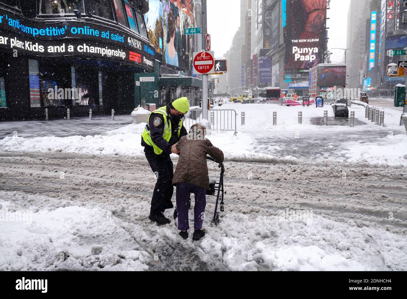 L'ufficiale del NYPD aiuta un anziano a attraversare una strada coperta di neve.la mattina dopo una potente tempesta invernale ha colpito gli stati nordorientali degli Stati Uniti, una grande tempesta di neve ha colpito la costa orientale degli Stati Uniti durante le prime ore del giovedì, creare ulteriori sfide nel bel mezzo di una pandemia di coronavirus e di una campagna di vaccinazione di massa che si svolge in tutta la regione. La tempesta invernale, che si sposta su New York, in Pennsylvania e in altri stati del nord-est, lascia milioni di persone che si trovano a fronteggiare più di un piede di neve una settimana prima di Natale, interrompendo potenzialmente i test dell'incoronavirus e ritardando le consegne delle festività. Ha inoltre lasciato oltre 60 mil Foto Stock