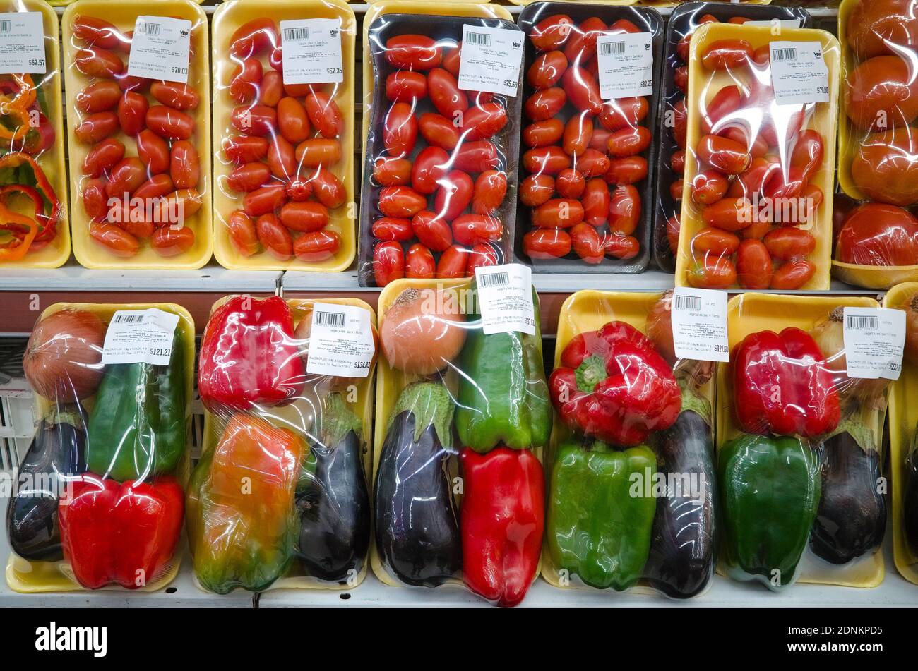 Set di verdure imballate in confezione di plastica nel supermercato. Pomodoro, pepe rosso e verde. Mendoza, Argentina Foto Stock