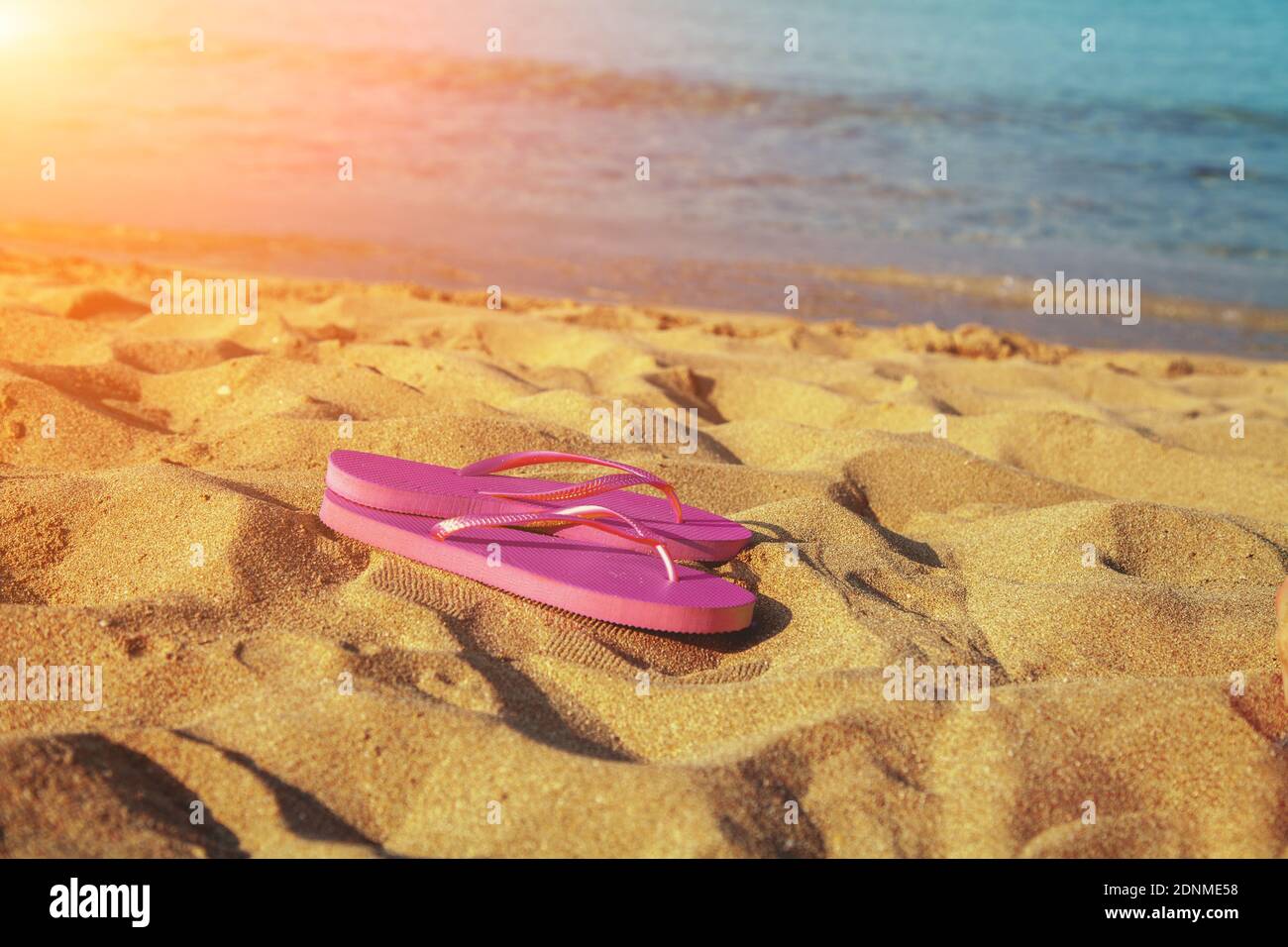 Sandali flip flop femminili sulla spiaggia all'alba Foto Stock