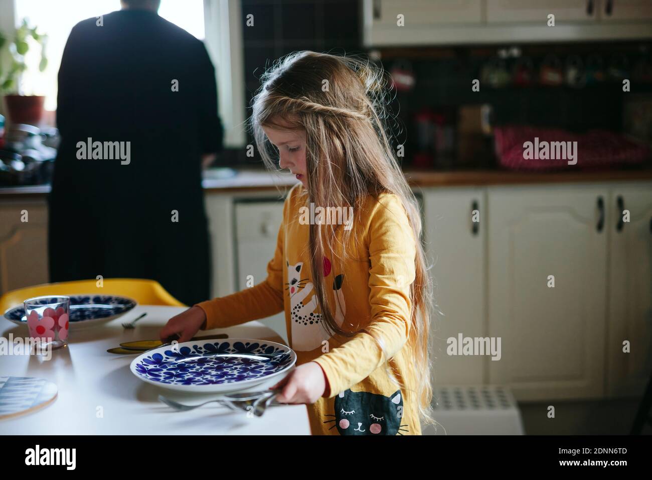 Ragazza nella tabella di impostazione Foto Stock