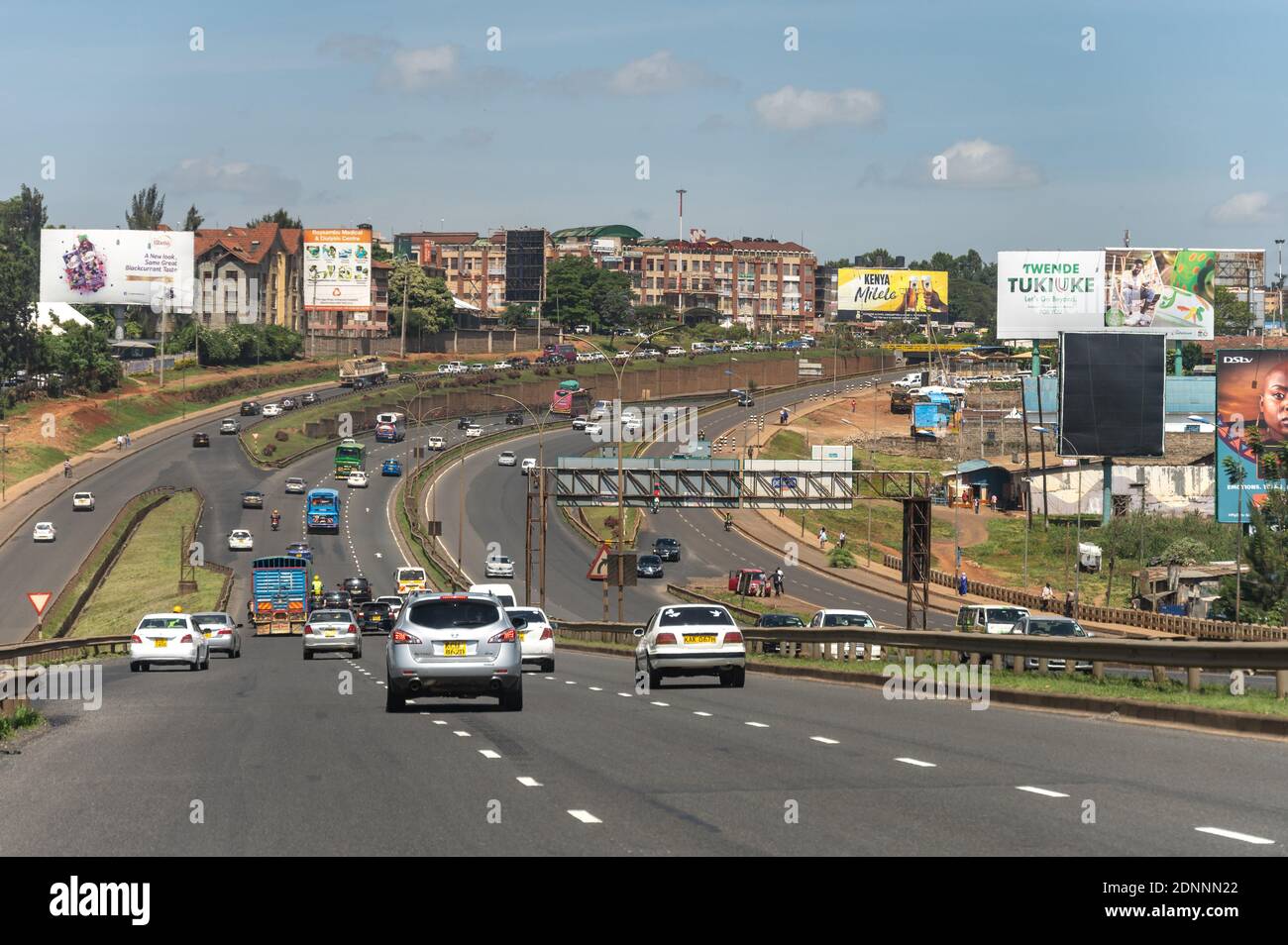 Veicoli che guidano sull'autostrada di Thika con traffico ed edifici, Nairobi, Kenia Foto Stock