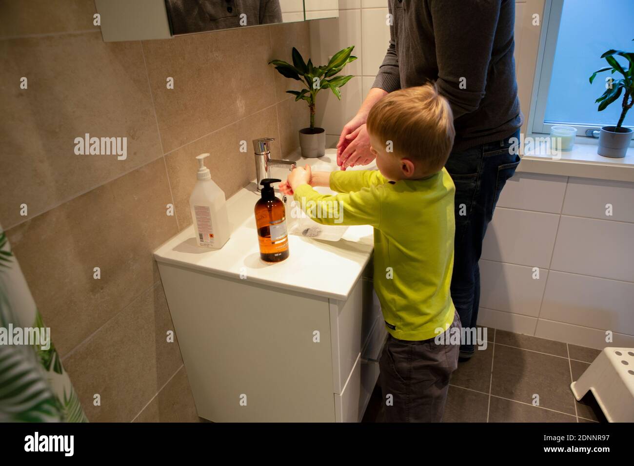 Padre e figlio lavano le mani in bagno Foto Stock