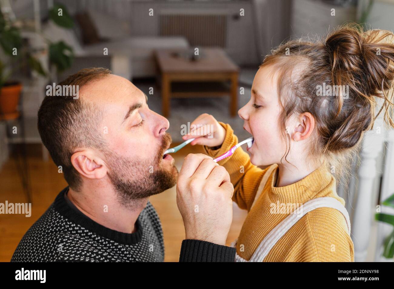 Padre e figlia si sfregano a vicenda i denti Foto Stock