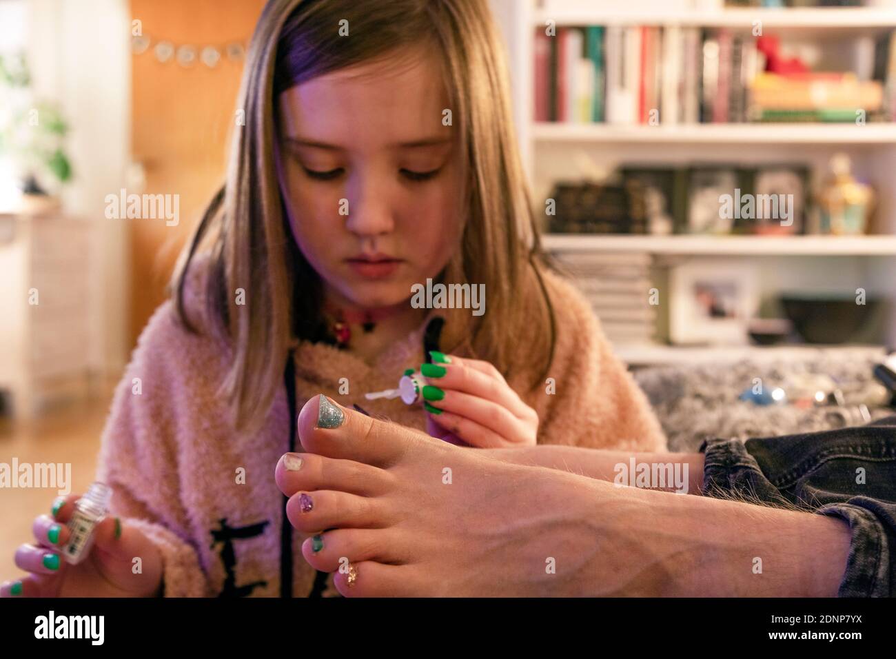 Ragazza che applica smalto per unghie sui toenails padri Foto Stock