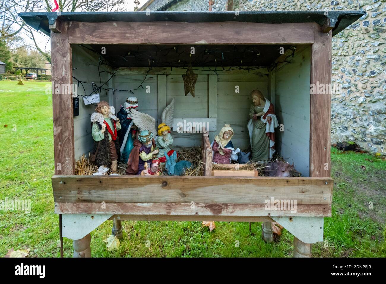 Presepio con figure bibliche appena prima di Natale fuori di una chiesa di villaggio, Regno Unito Foto Stock