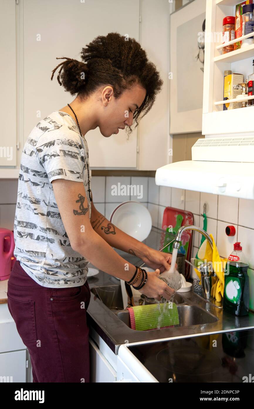 L'uomo lavaggio piatti in cucina Foto Stock