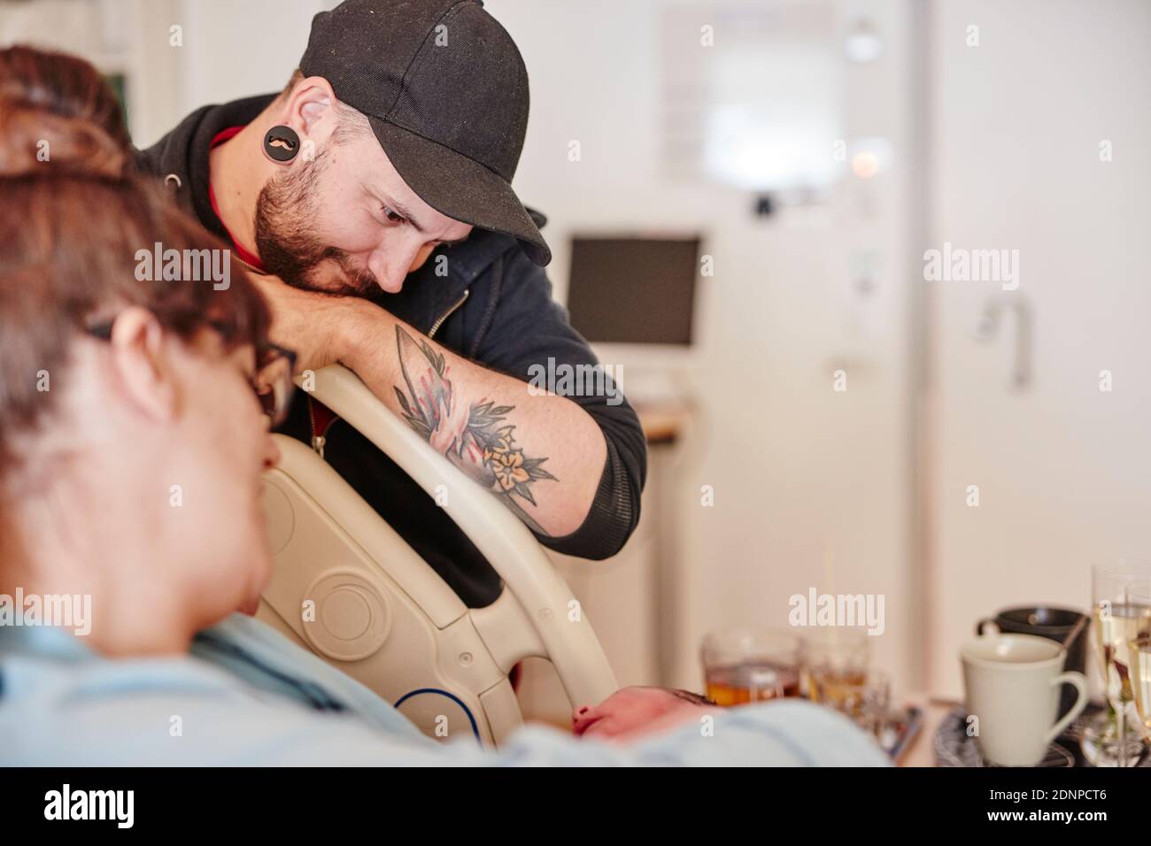Padre in ospedale che guarda il neonato Foto Stock