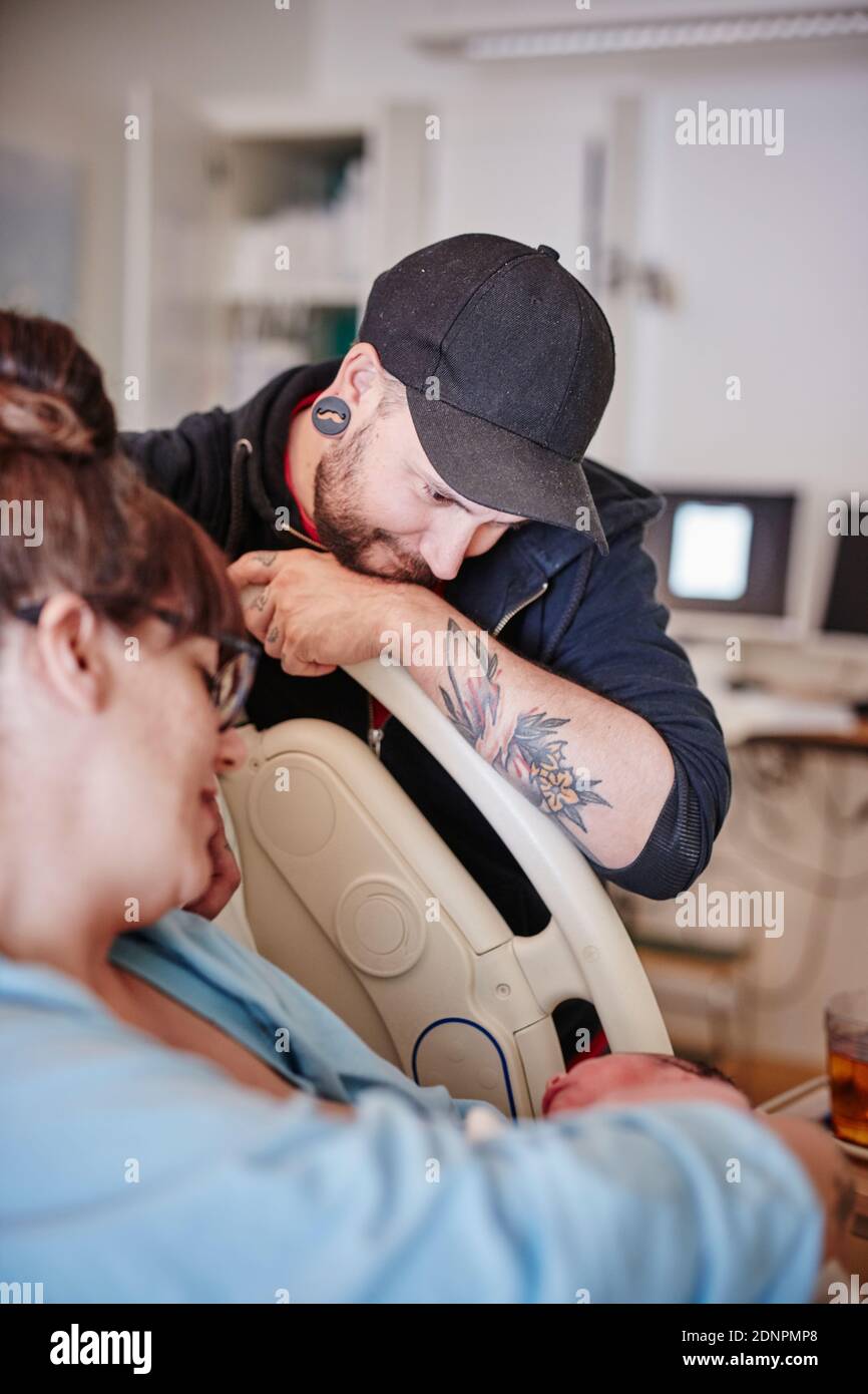 Padre in ospedale che guarda il neonato Foto Stock