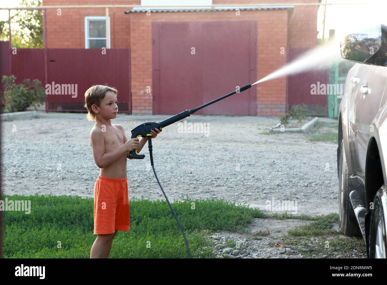 Lavaggio auto per bambini con lavatore ad alta pressione Foto Stock