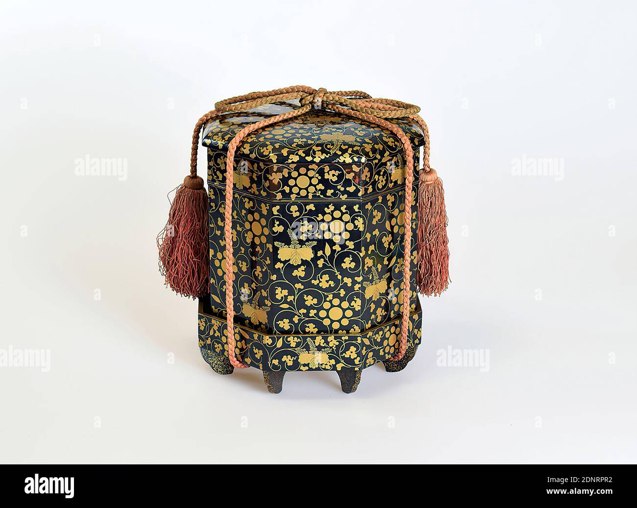 Scatola giochi con tendini e stemma, proprietario precedente: Rex & Co, Berlino, legno, laccato, lacca nera, makie in oro e argento su legno, totale: Altezza: 19.7 cm; larghezza: 16.3 cm; profondità: 16.3 cm, lacca, stemmi (insignia), periodo Edo, la scatola per riporre le conchiglie per il gioco delle conchiglie (kaiawase) è decorata con tendri e due stemmi in un modello piatto sparso (hiramakie). Lo stemma Paulownia (kiri-mon) e lo stemma nove stelle (kuyō-mon) con stelle stilizzate sono stemmi di famiglia della famiglia Hosokawa Foto Stock