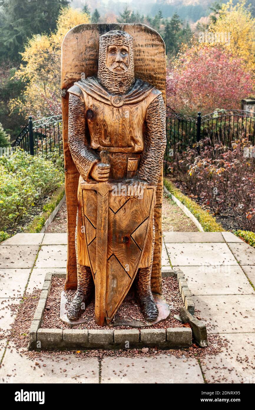 Una scultura con motosega in legno di William Wallace scolpita da Iain Chalmersin 2016 e situato nel giardino William Wallace Rose A Castlebank Park in LAN Foto Stock
