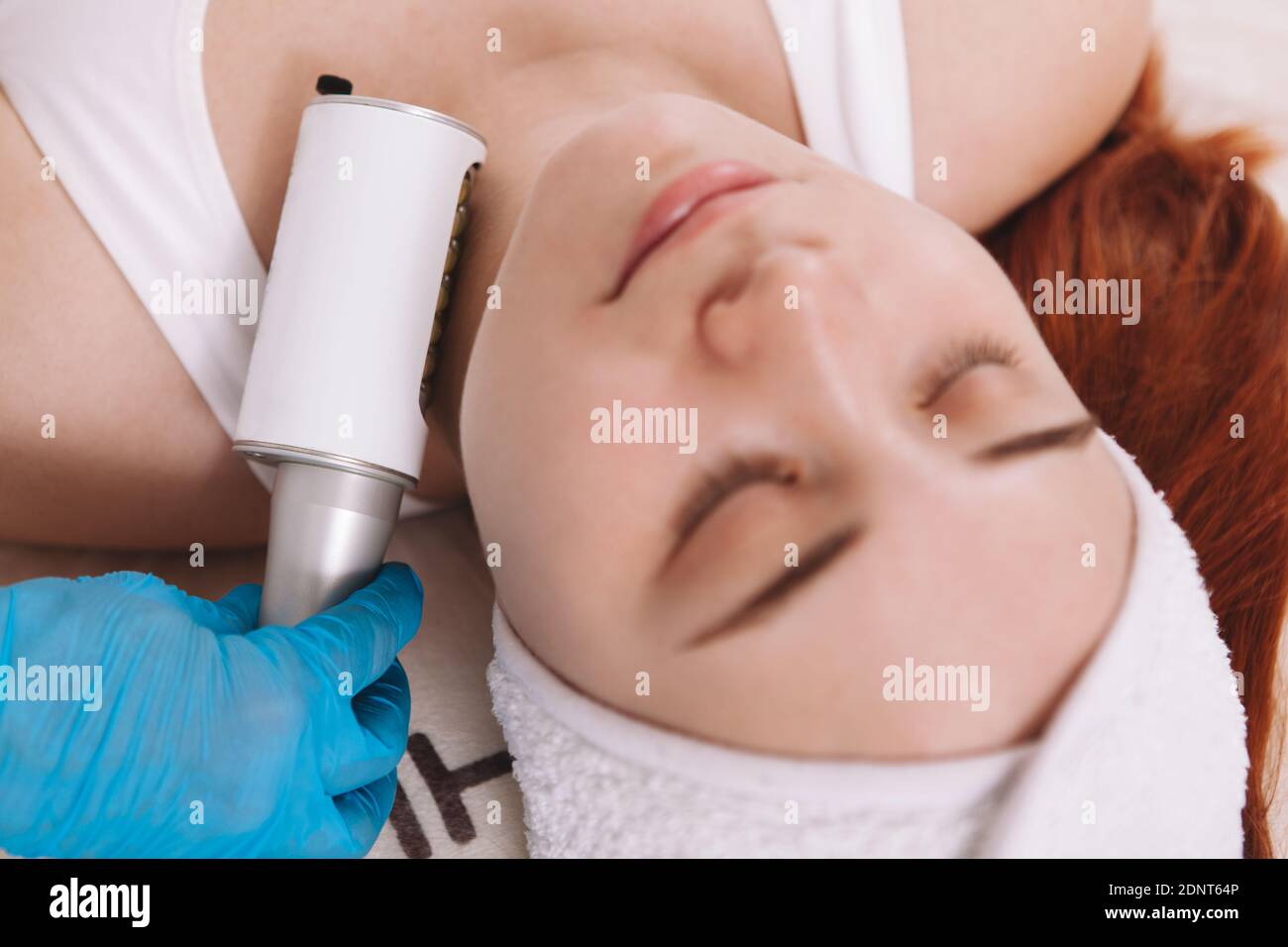 Vista dall'alto ripresa tagliata di una donna che si rilassa al salone di cosmetologia, ottenendo trattamento delle endosfere facciali Foto Stock
