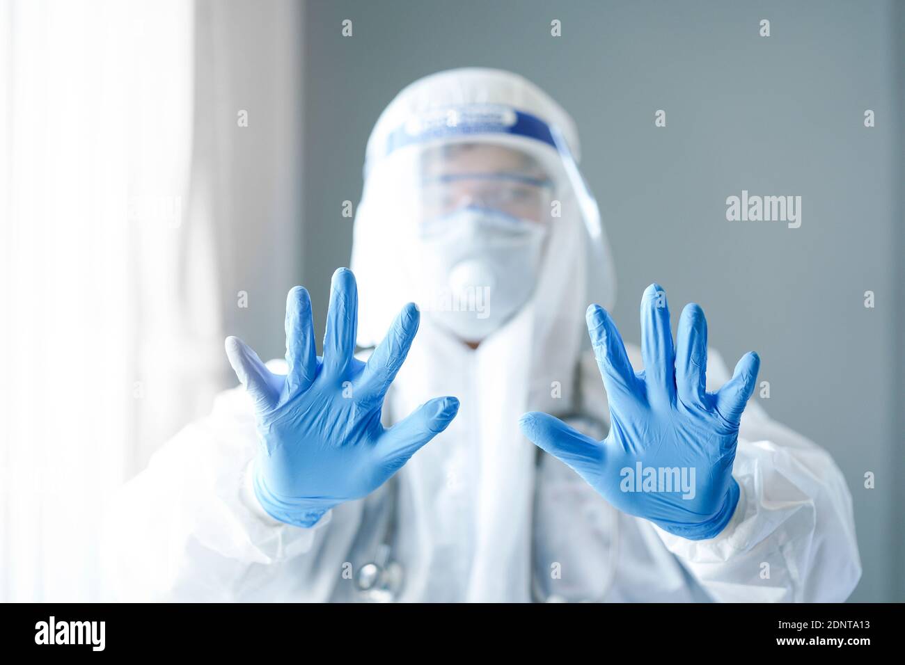 Ritratto di un medico che indossa un PPE protettivo che tiene le mani su Foto Stock
