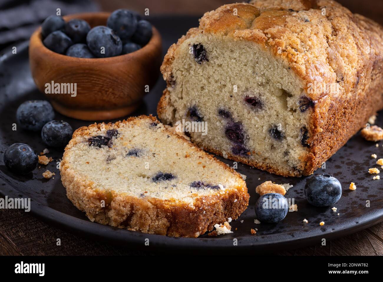 Pane di mirtillo streusel dolce affettato su un piatto con mirtilli freschi Foto Stock