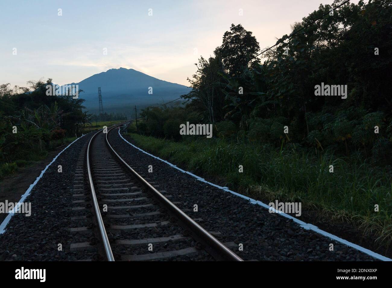 Jember - binari ferroviari Banyuwangi con lo sfondo del Monte Raung. Foto Stock