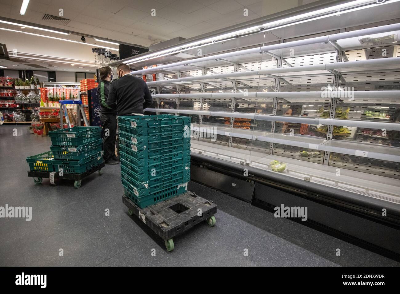 Scaffali vuoti di generi alimentari in un supermercato M&S durante la costruzione fino alla settimana di Natale, poiché i confini dell'UE sono chiusi e i camion non sono in grado di consegnare le merci. Foto Stock