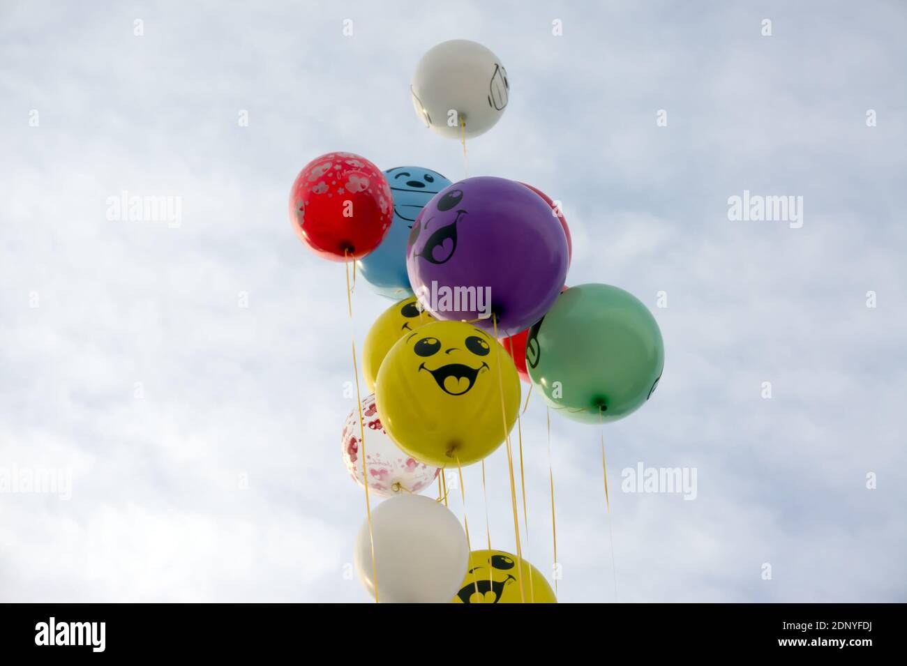 Un mazzo di palloncini multicolore si innalzano fino al cielo nuvoloso. Foto Stock