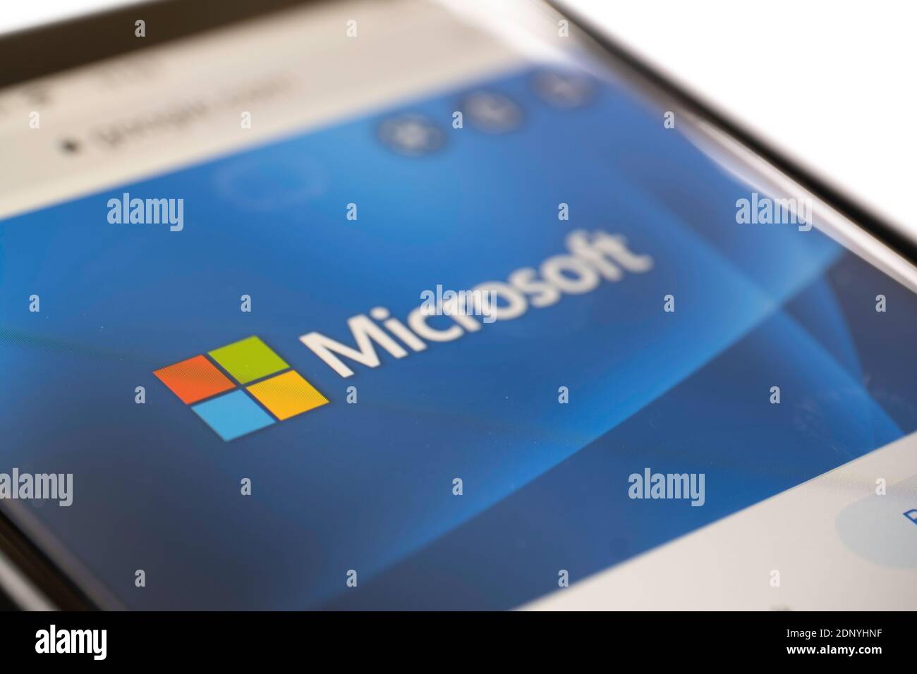 Primo piano del logo Microsoft su un telefono cellulare con profondità di campo ridotta. Mettere a fuoco sul logo colorato. Isolato su bianco Foto Stock