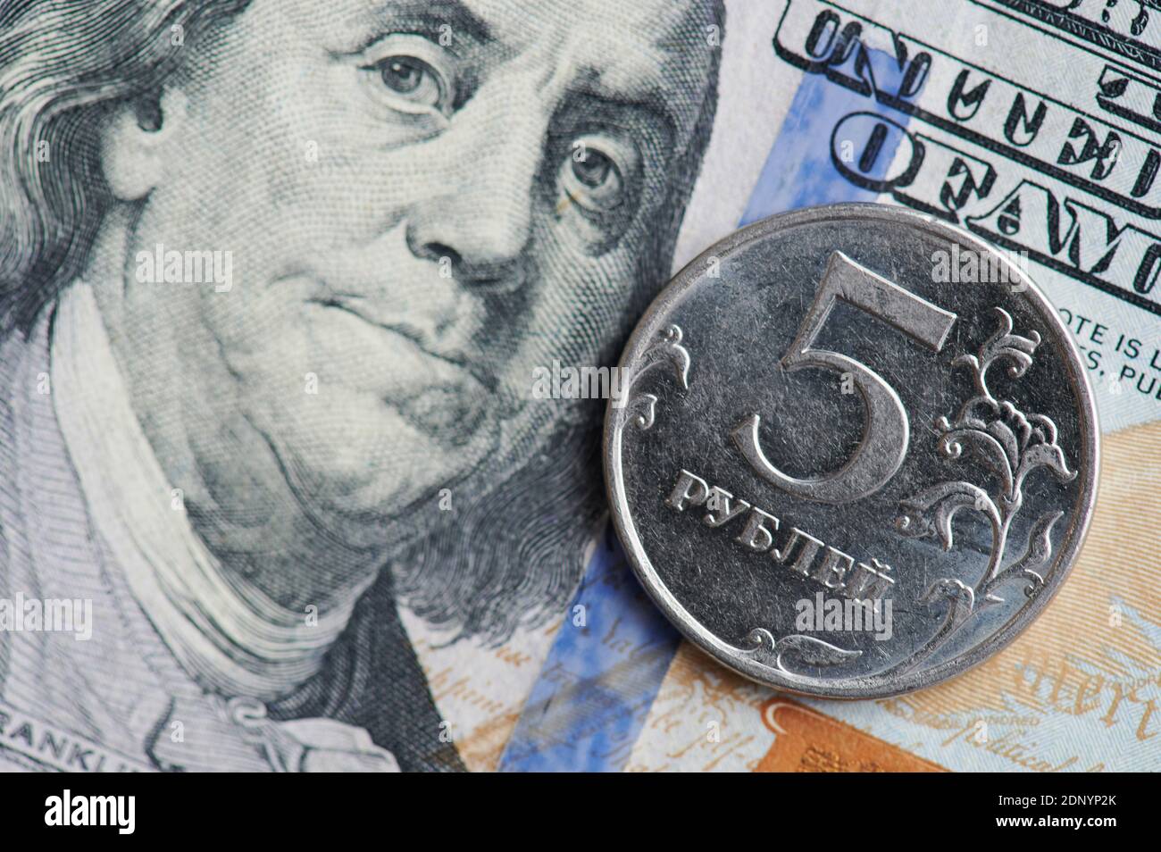 Tema della valuta americana e russa. Moneta di metallo su fondo di fattura di 100 dollari Foto Stock