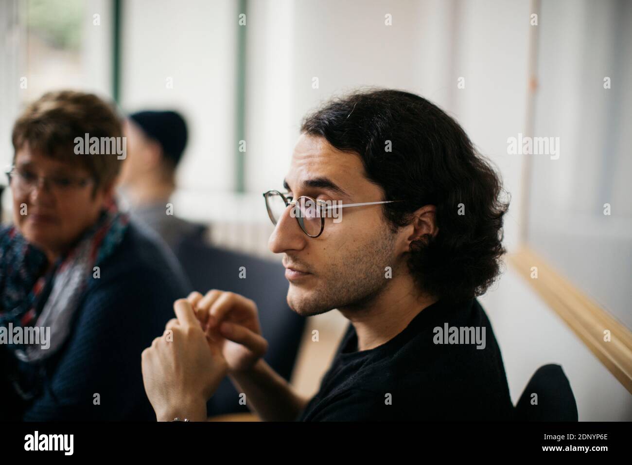 Uomo medio adulto che ascolta durante la riunione informale Foto Stock