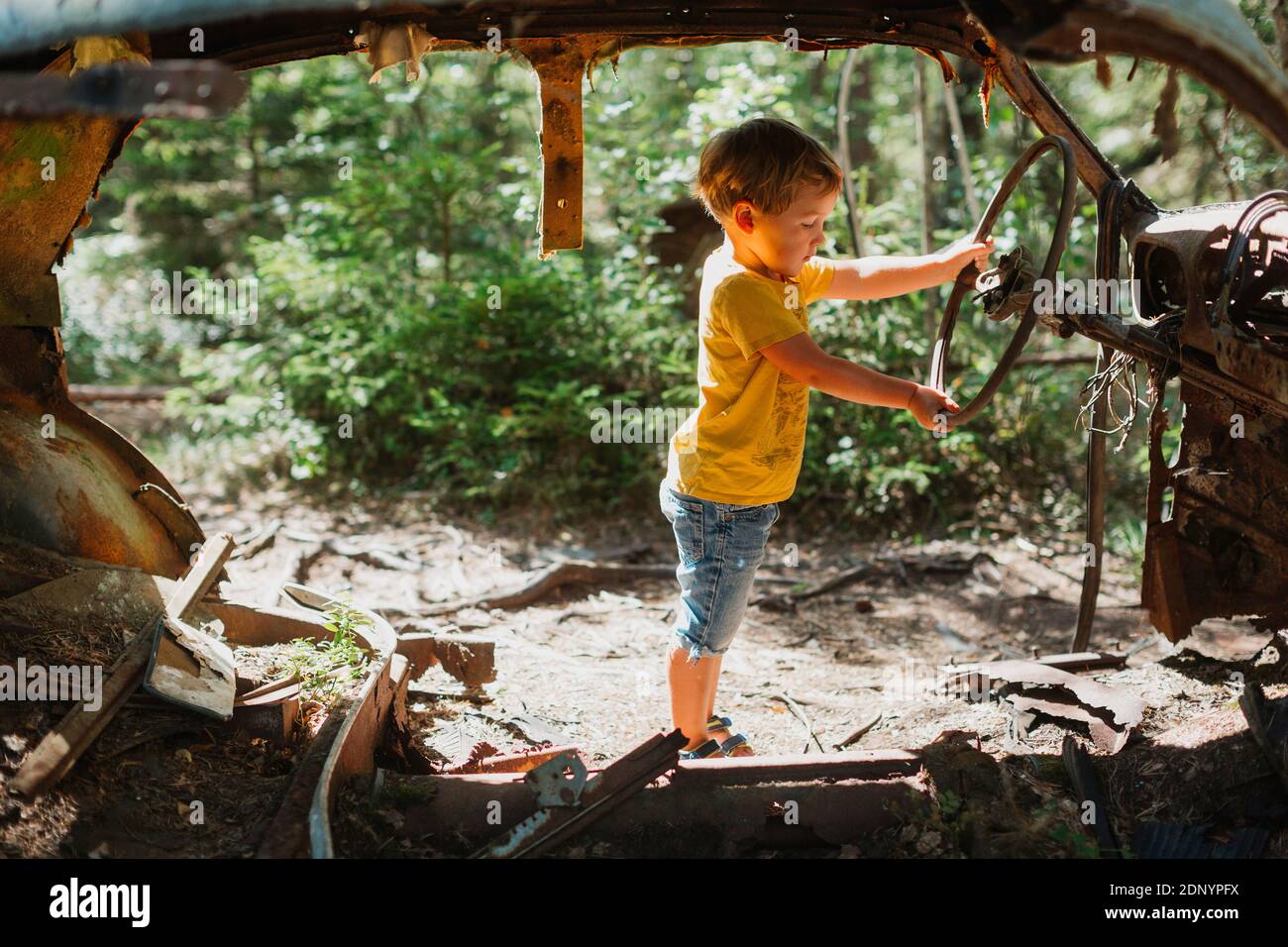 Ragazzo che gioca in auto distrutta Foto Stock