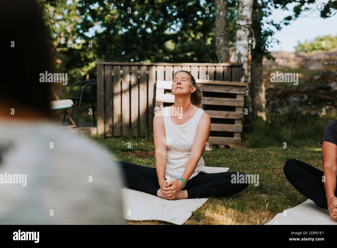 La donna a praticare yoga in giardino Foto Stock