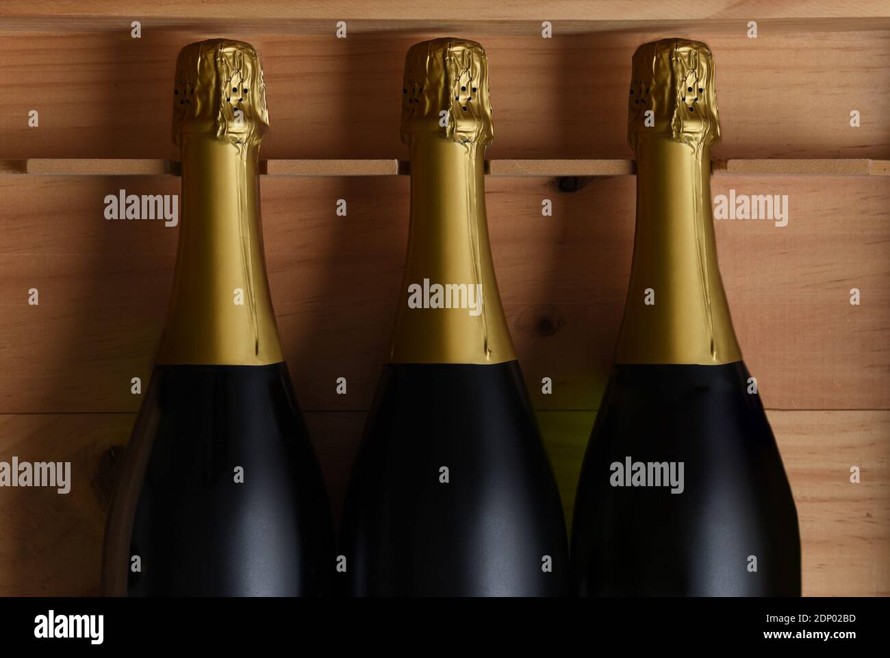 Primo piano di tre bottiglie di champagne in una cassa di legno. Foto Stock