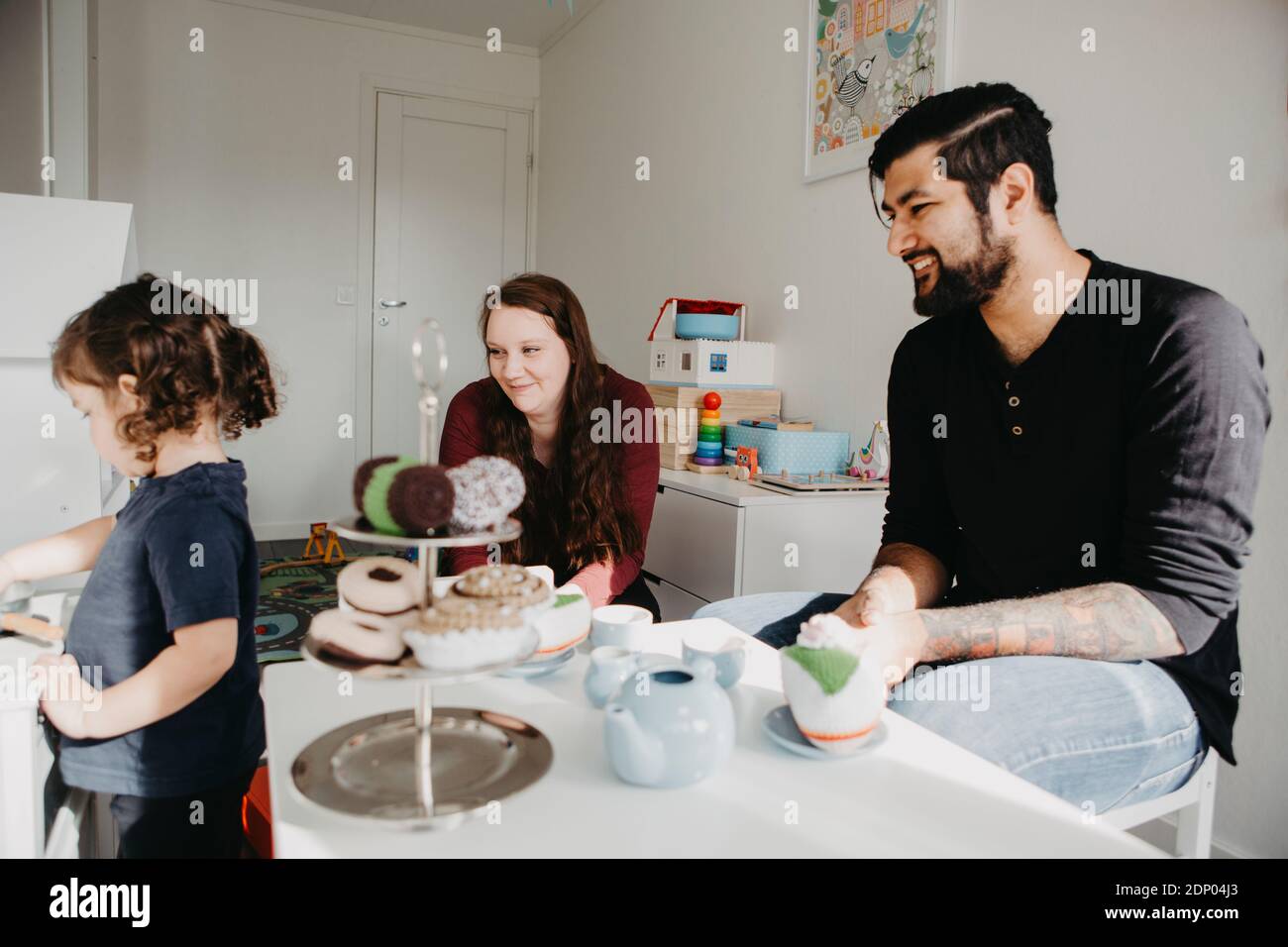 Ragazza che ha una festa del tè con i genitori Foto Stock