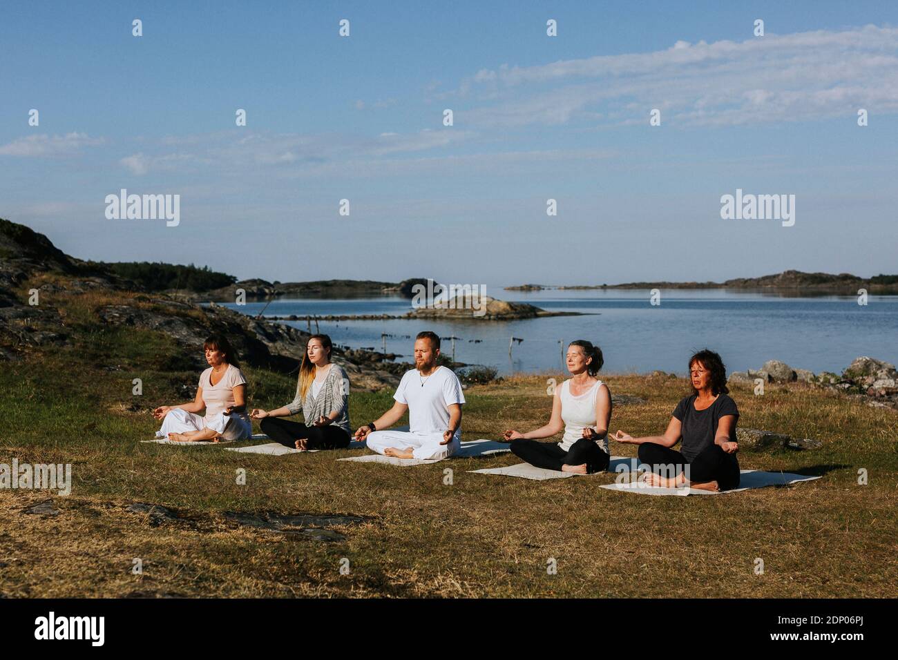 Persone che meditano in mare Foto Stock