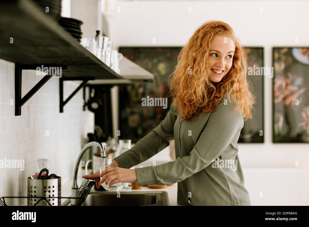 Donna sorridente in cucina d'ufficio Foto Stock