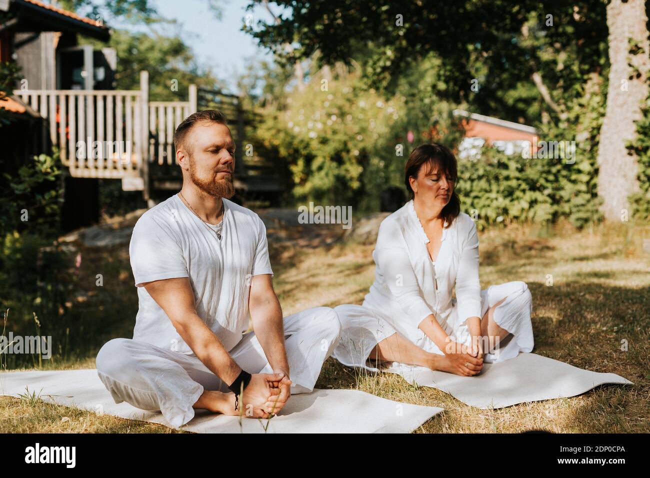 Persone che praticano yoga in giardino Foto Stock
