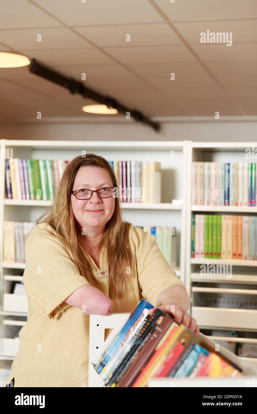 Donna sorridente che lavora in biblioteca Foto Stock