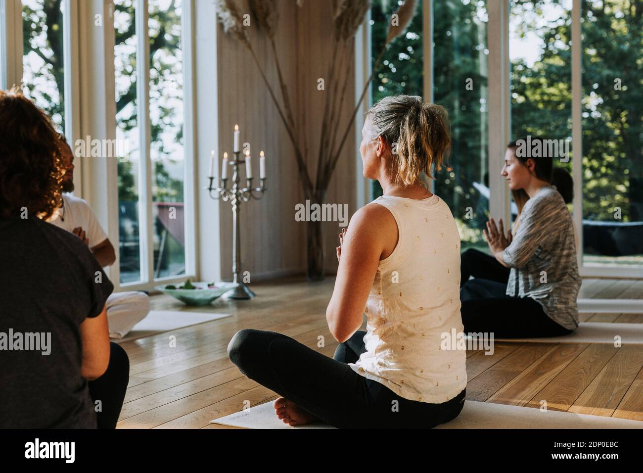 Persone che praticano lo yoga in classe Foto Stock