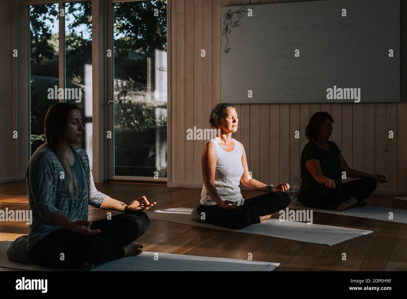 Donne meditando in studio di yoga Foto Stock