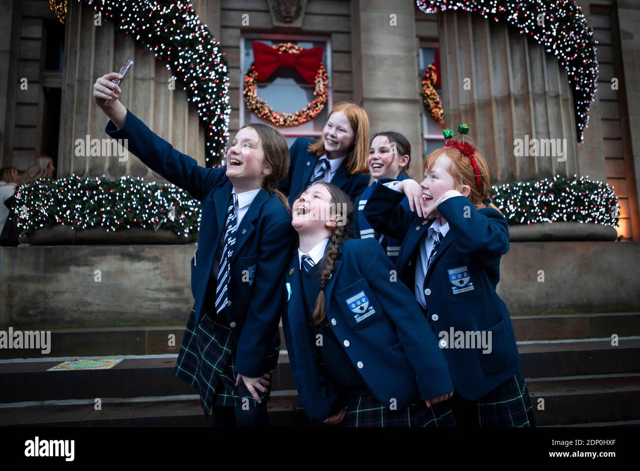 Gli alunni P6 della George Heriot's School celebrano la fine del termine con un selfie accanto alle decorazioni natalizie fuori dal Duomo di George Street, Edimburgo. Foto Stock