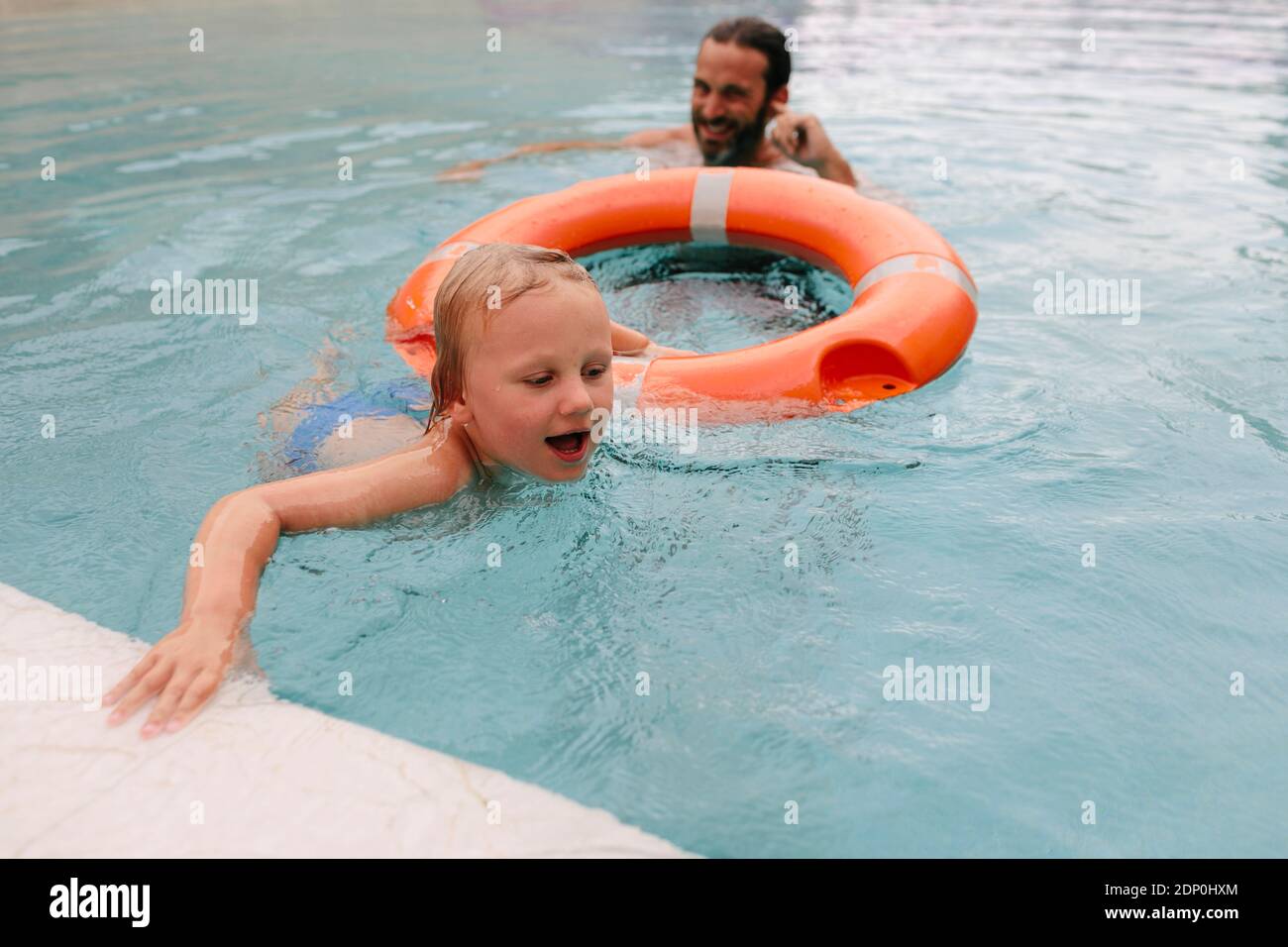 Ragazzo con padre in piscina Foto Stock