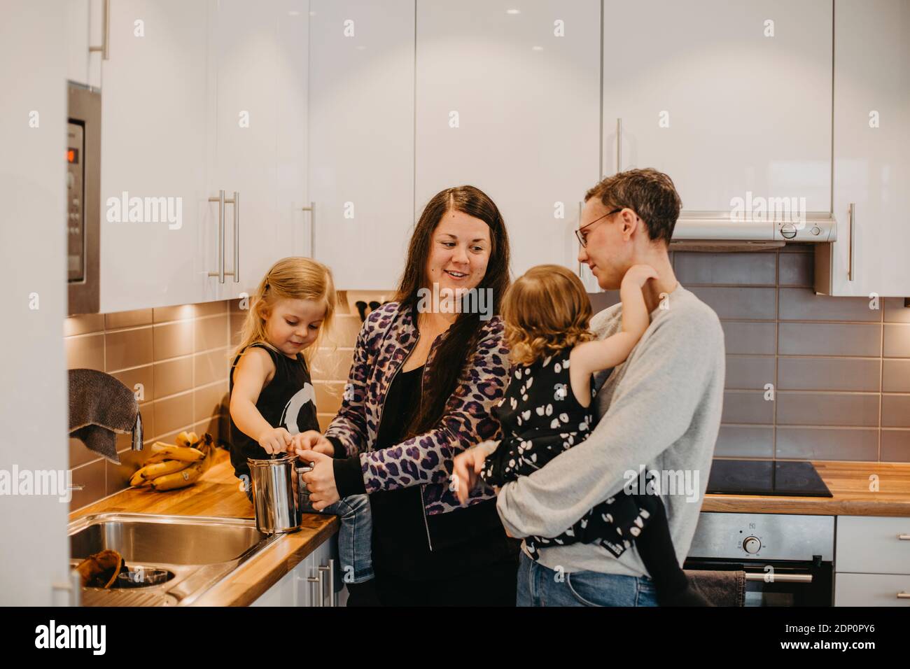Donne con due figlie in cucina Foto Stock