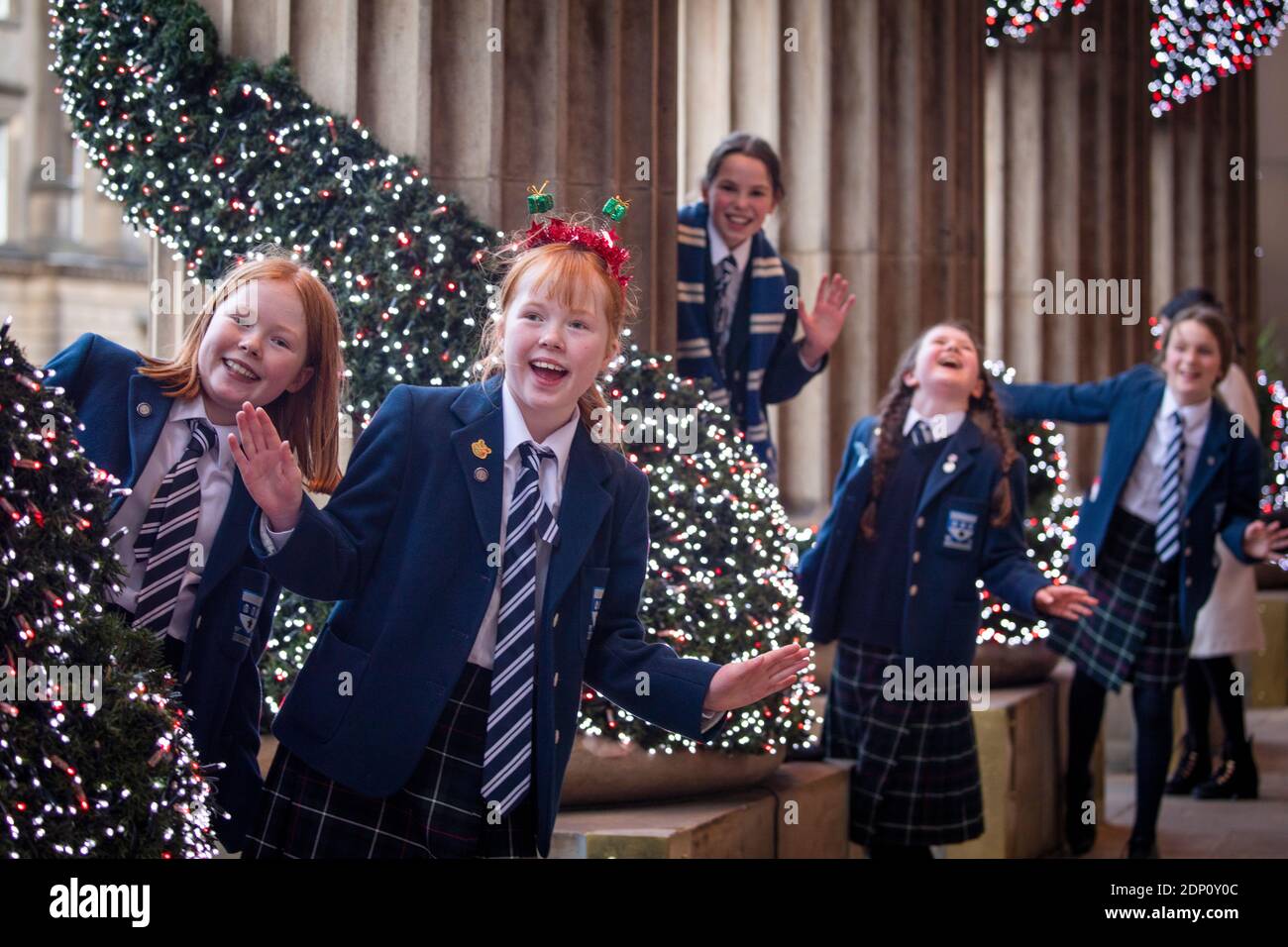Gli allievi P6 della George Heriot's School celebrano la fine del termine insieme alle decorazioni di Natale fuori del Duomo in George Street, Edimburgo. Foto Stock